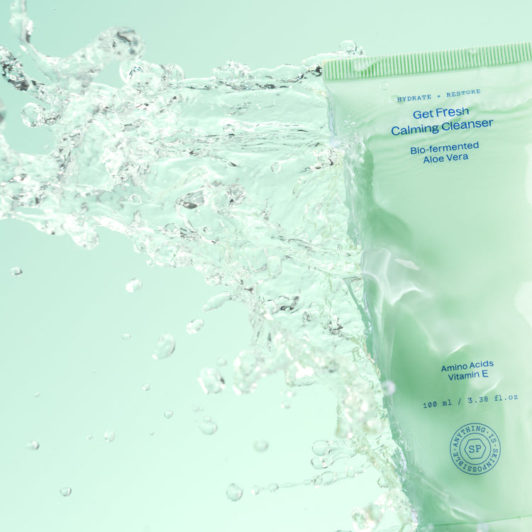 Get Fresh Calming Cleanser tube with water splashing across it against a mint green background